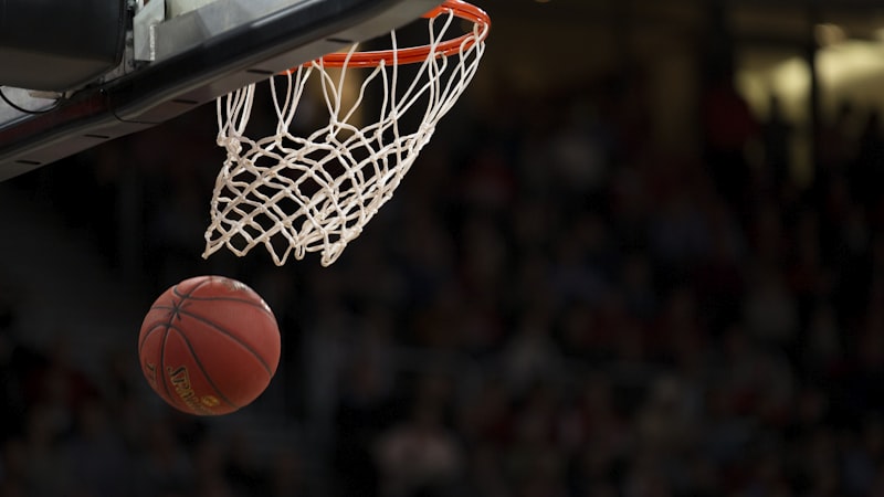 NBA篮球比赛现场，球员正在激烈对抗，比分牌显示实时数据